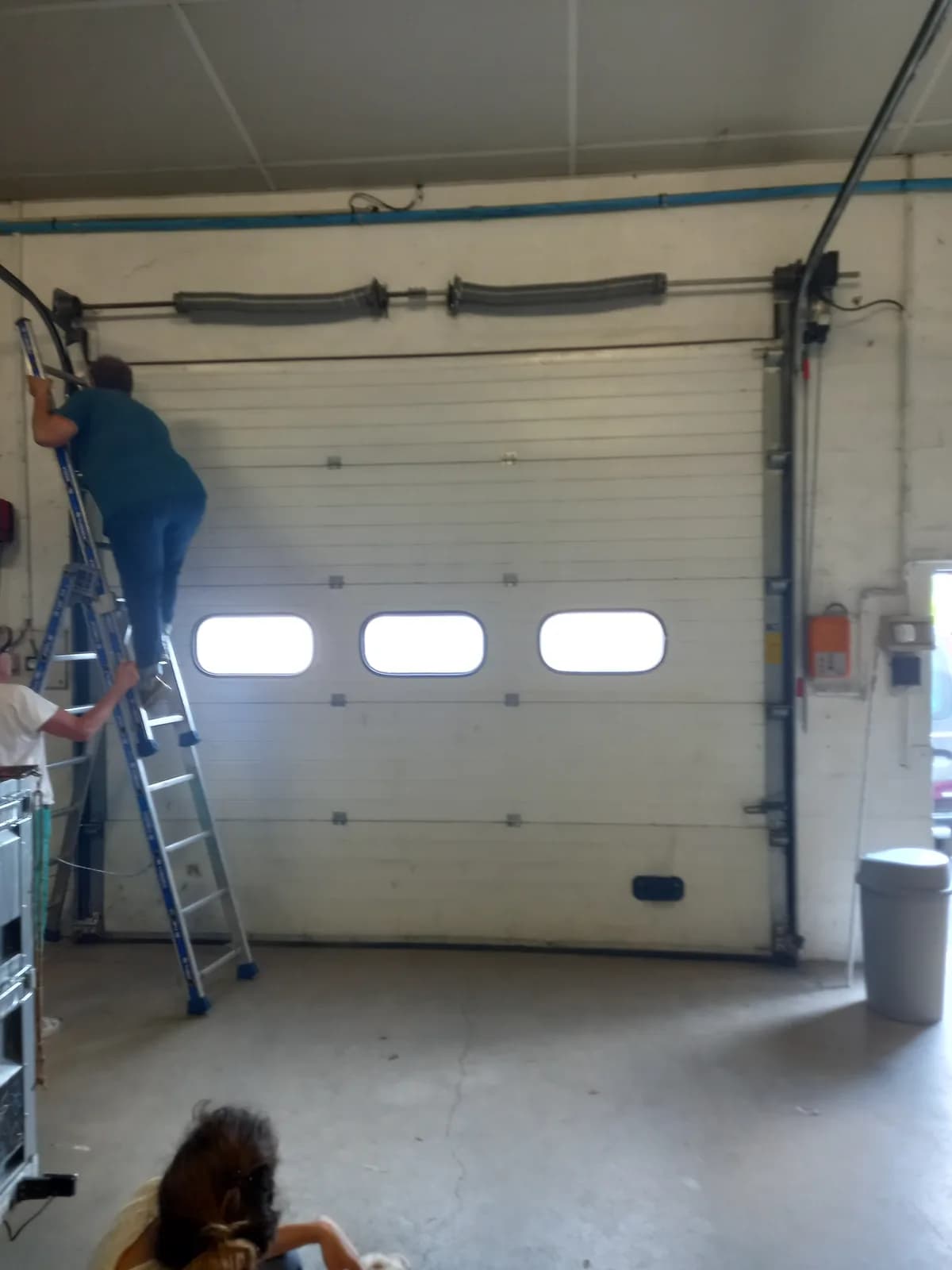 Intervention sur porte de garage sectionnelle en atelier — Chris Artisan Bordeaux